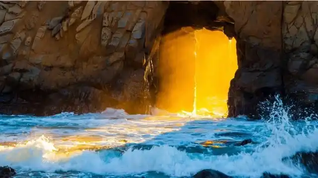 A water filled cave with an opening in the middle with sunlight creeping inside.