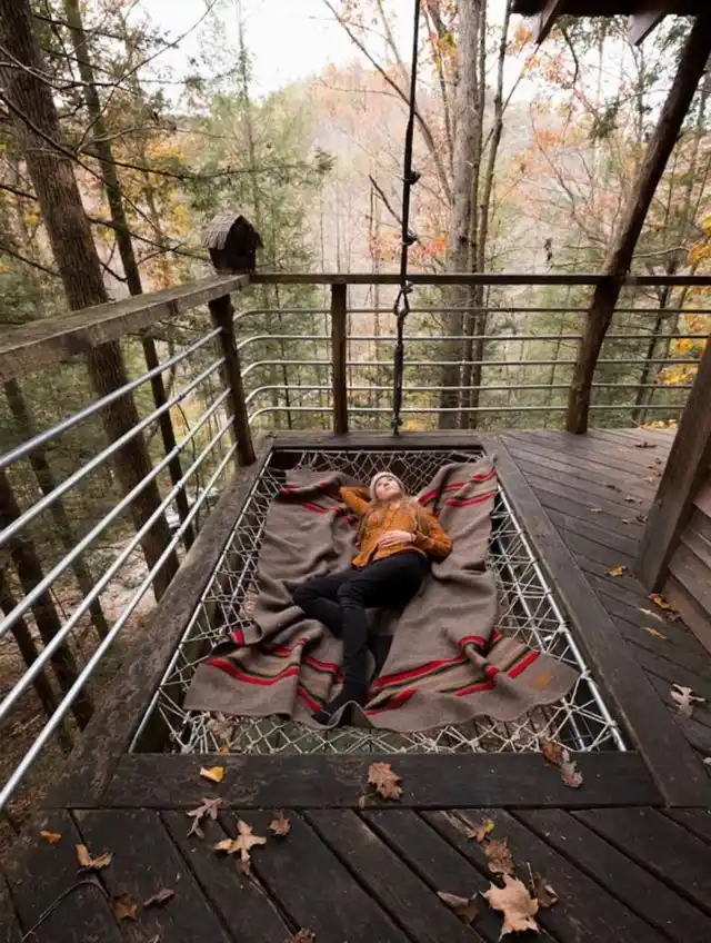 A women lying in the verandah of her house situated in the woods.
